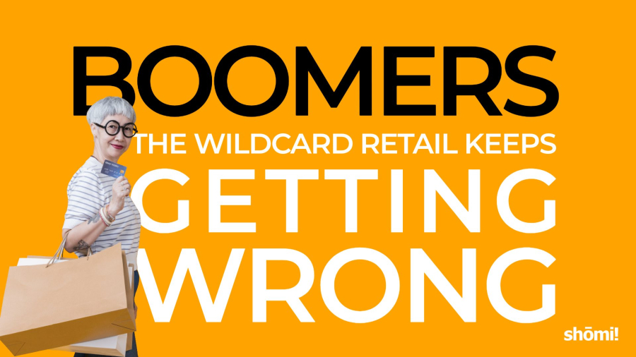 A stylish older person holding shopping bags and a credit card stands in front of bold text: “Boomers, the wildcard retail keeps getting wrong.” The background is bright orange with the shomi! logo.