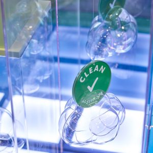 Clear, bubble-like spheres hanging in a display, each topped with a green Clean at Sephora circular tag.